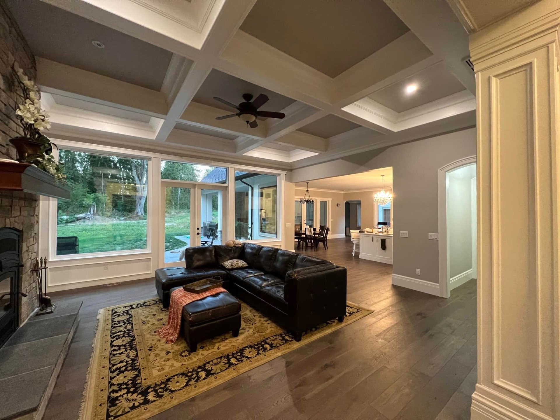 Finished living room with coffered drywall ceiling and stone fireplace