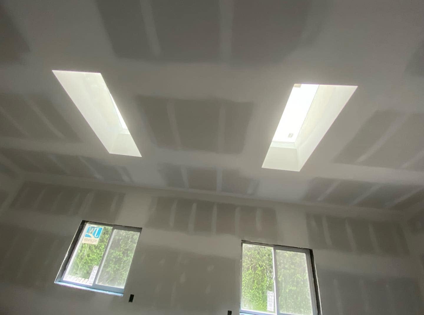 Drywalled ceiling with skylights freshly taped and mudded