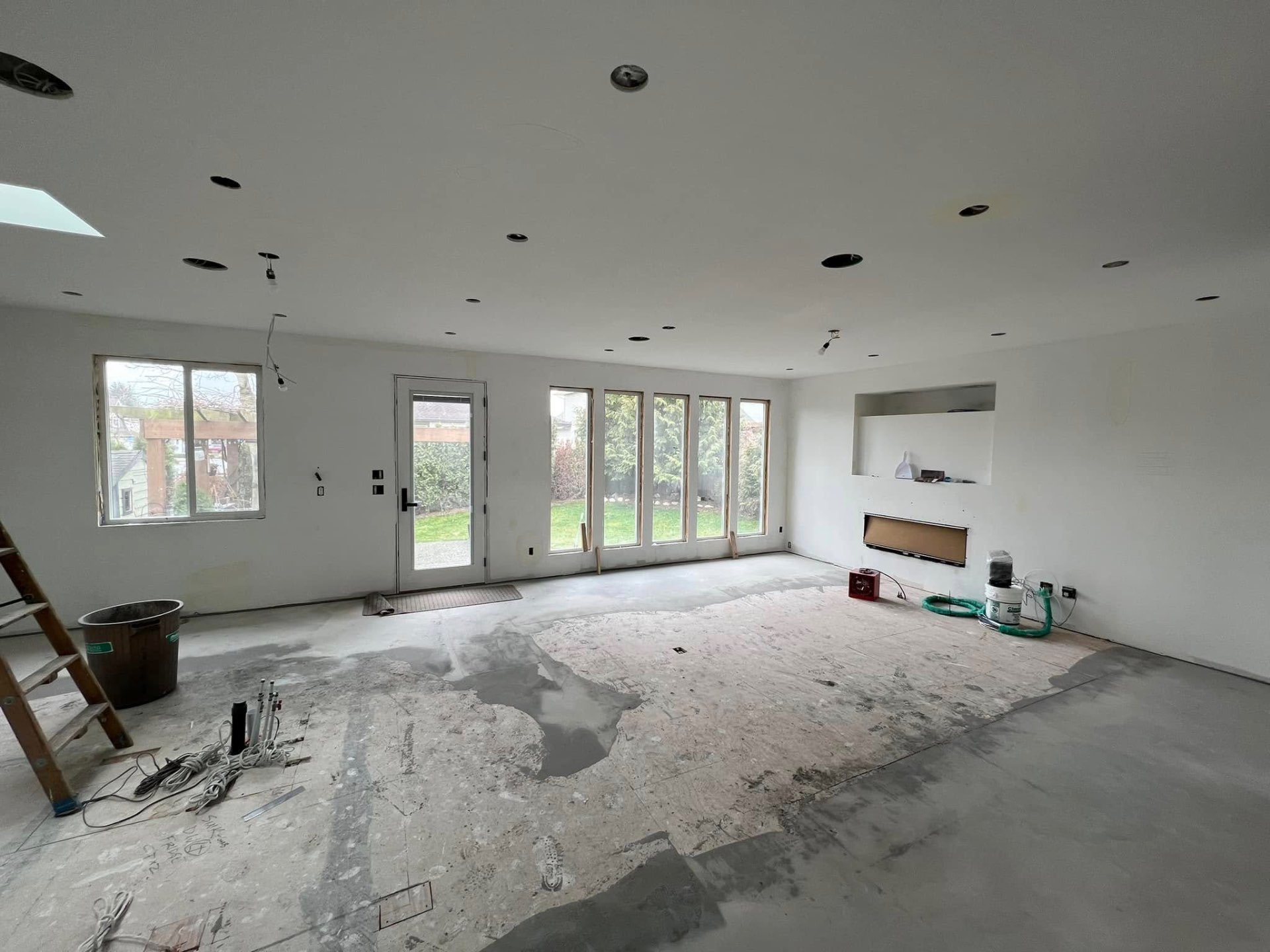 Renovated great room with finished drywall and large windows