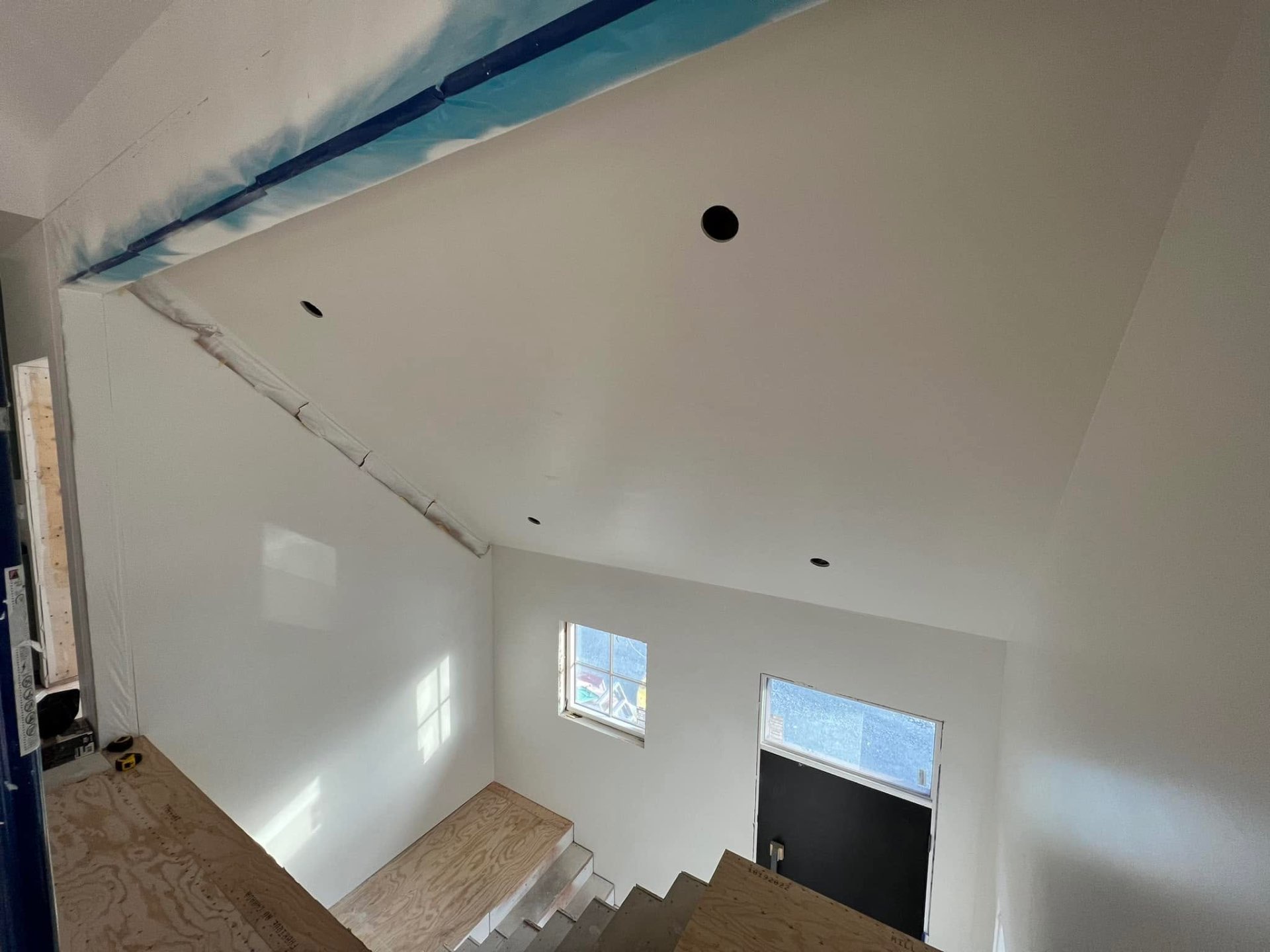 Bright stairwell with smooth drywalled walls and sloped ceiling
